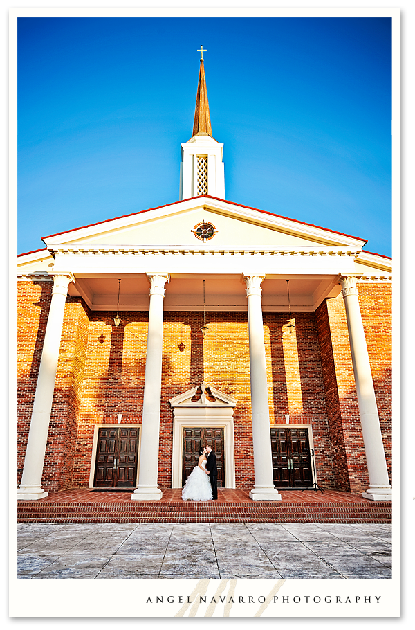 Outdoor photo of church with bride and groom.